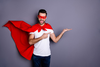 Homme souriant en cape rouge, bras tendu