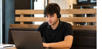 Jeune homme travaillant sur ordinateur portable avec casque