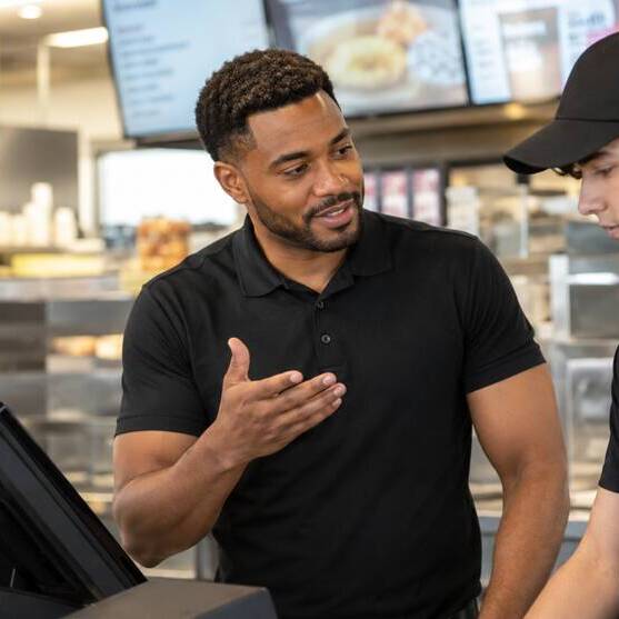 Deux employés discutent derrière un comptoir de restauration